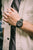 Pulsera de reloj para hombre en primer plano en la muñeca, esfera negra, correa de eslabones metálicos