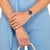 Reloj de mujer en la muñeca con esfera azul y correa de acero inoxidable