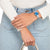 "Reloj de mujer en la muñeca con esfera azul y pulsera de metal plateado"