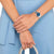 Reloj de mujer en la muñeca con esfera azul y pulsera de acero inoxidable, llevado con ropa azul claro