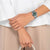 Reloj de mujer en la muñeca con esfera verde y correa de acero inoxidable plateado