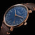 Reloj de hombre con esfera azul, caja dorada y correa de cuero marrón