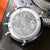 Reverso del reloj de pulsera para hombre con grabado en caja plateada y corona brillante