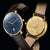Relojes de hombre comparados: esfera azul con correa de cuero marrón y fondo dorado