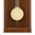 Detalle de reloj de pared de madera: péndulo redondo con soportes dorados delante de un marco de madera marrón
