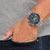 Reloj de hombre en la muñeca con esfera azul y correa de acero inoxidable plateado