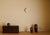 Kleine gelbe runde Wanduhr an der Wand mit minimalistischen Zeigern