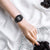 Damenuhr mit schwarzem Digitaldisplay und schwarzem Armband am Handgelenk, seitlich