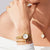 Damenuhr mit rundem weißem Zifferblatt und goldfarbenem Milanaise-Armband