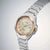 Vista lateral de reloj de pulsera para hombre con esfera dorada y correa de acero inoxidable plateado