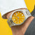 Reloj Citizen Tsuyosa automático en la muñeca, esfera amarilla, correa de acero inoxidable