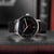 Reloj automático unisex con correa de cuero negra, esfera negra y segundero rojo
