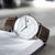 Reloj de hombre vista frontal: esfera blanca, correa de cuero marrón y caja plateada