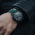 Pulsera de hombre en la muñeca, esfera negro-verde oscuro, correa de caucho