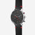 Reloj Hamburg Chrono Edition, esfera negra y plateada, con detalles vintage en negro y rojo, visto desde un ángulo de 45 grados sobre fondo gris.