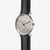 "Reloj de pulsera para hombre visto de frente: esfera beige con escala de horas, correa de cuero negra."