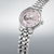 Reloj de hombre con esfera rosa y pulsera de metal plateado, vista lateral