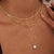 Collar dorado multicapa con colgante de perlas y detalle de joya redonda