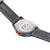 Parte trasera de un reloj deportivo con grabado "Never Give Up", correa negra y detalle rojo
