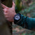 Reloj de hombre en la muñeca: reloj deportivo azul oscuro con detalles rojos y esfera de cronógrafo