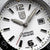 Primer plano de reloj de hombre: esfera blanca con índices grandes y ventana de fecha 31