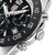 "Reloj de hombre, detalle lateral: bisel negro, corona y caja con marcadores."