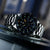 Reloj de pulsera para hombre con esfera negra, manecillas luminosas y bisel de acero inoxidable en detalle