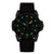 Pulsera de hombre con correa de goma negra, esfera oscura e índices verdes luminosos.
