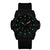 Reloj de hombre con esfera negra, marcadores luminosos verdes y correa negra.