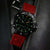 Reloj automático con esfera negra, correa de silicona roja y negra y marcadores luminosos