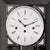 Primer plano de la esfera de un reloj de pared con escala blanca, manecillas negras y números romanos