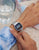 Casio reloj digital en la muñeca con correa de metal plateada y pantalla LCD azul