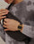 Reloj digital vintage en la muñeca con correa de metal negra y pantalla digital dorada