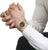 Pulsera unisex en la muñeca con correa de malla dorada y esfera verde oscuro