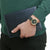 "Reloj de mujer en la muñeca con esfera verde oscuro, bisel dorado y correa verde"