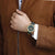 Reloj unisex en la muñeca con esfera verde oscuro y correa de tela verde oscuro.