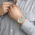 Reloj unisex: esfera gris claro con manecillas rojas y correa gris.
