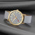 Reloj unisex con esfera gris claro, bisel dorado, manecillas rojas y correa gris.