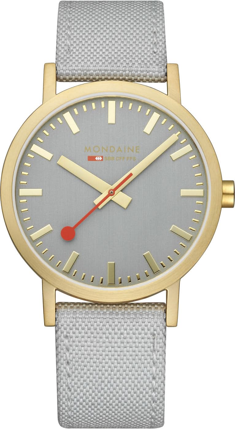 Reloj unisex: esfera gris claro, bisel dorado, correa de tela gris.