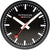 Reloj de pared negro con índices blancos, manecillas rojas y logo Mondaine en la esfera