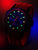 Reloj de hombre con caja negra y correa de silicona roja, manecillas luminosas