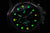 Pulsera de hombre, vista de cerca: brillo verde en esfera negra