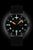 Reloj de hombre con esfera negra, marcadores luminosos naranjas y correa de cuero