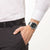Pulsera de hombre en la muñeca con esfera negra y correa de metal plateado