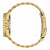 Vista lateral de un reloj de hombre dorado con corona y bisel estriado