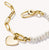 Pulsera de eslabones en tono dorado con perlas blancas y charm en forma de corazón en el eslabón de conexión