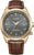 Reloj de hombre con correa de cuero marrón, bisel dorado y esfera oscura, ventana de fecha