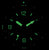 "Reloj de mujer con índices y manecillas verdes luminosos en esfera oscura"