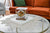 Reloj de mesa en caja de cristal transparente con esfera redonda sobre base blanca