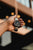 Pulsera de hombre con esfera negra en la muñeca en una mano